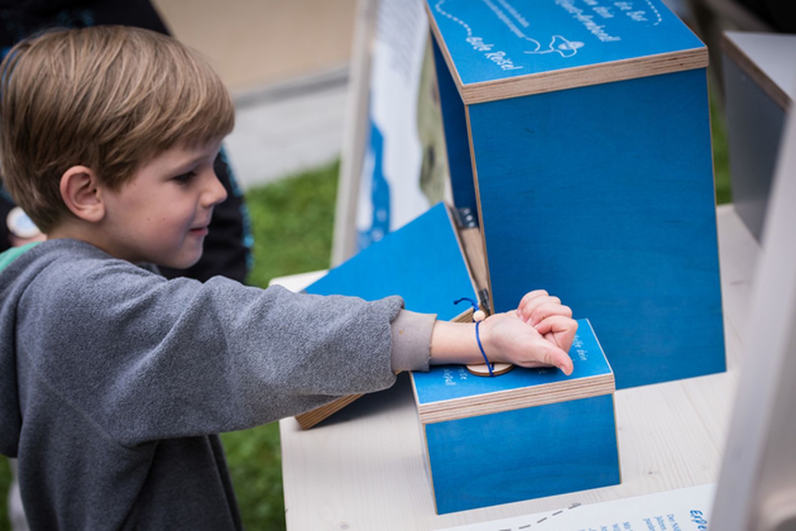 Kind scannt Armband an Ausstellung ein