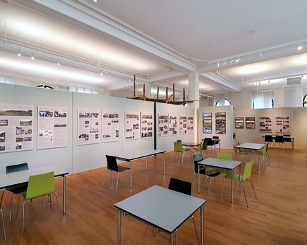 Ausstellungsraum mit Tischen und Stühlen