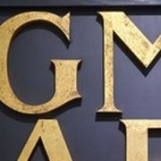 Goldene Buchstaben (GMAE) auf schwarzem Hintergrund