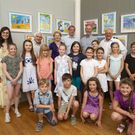 Kindergruppe vor gemalten Bildern