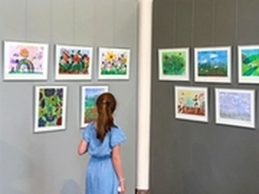 Kind schaut Bilder in Ausstellung an