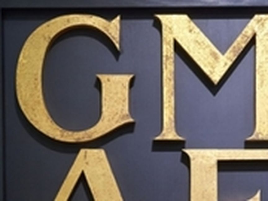 Goldene Buchstaben (GMAE) auf schwarzem Hintergrund